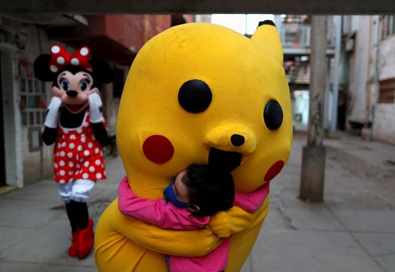 A volunteer wearing a costume of Pokemon character Pikachu hugs a child during Children's Day in Buenos Aires, Argentina. REUTERS/Agustin Marcarian  